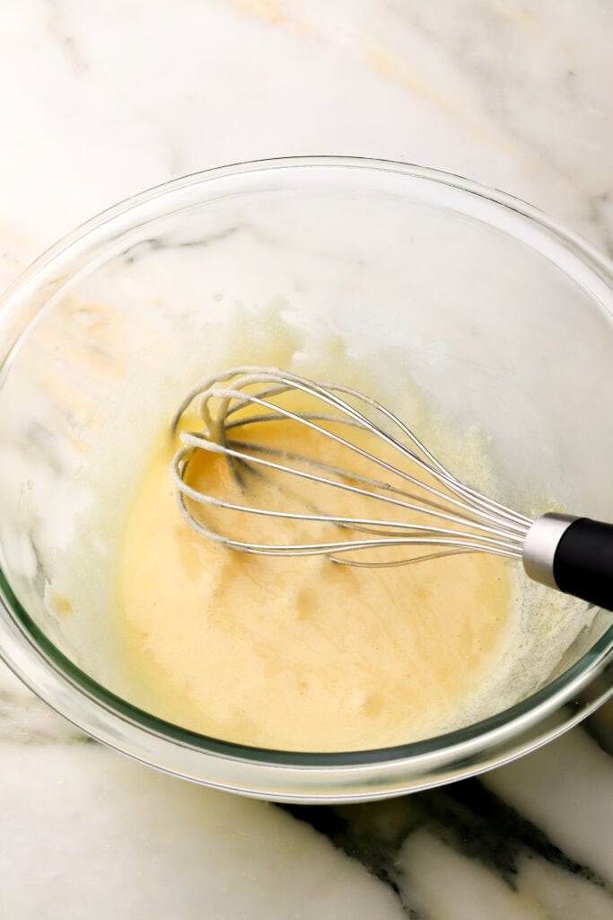 egg yolks and sugar combined in a glass bowl