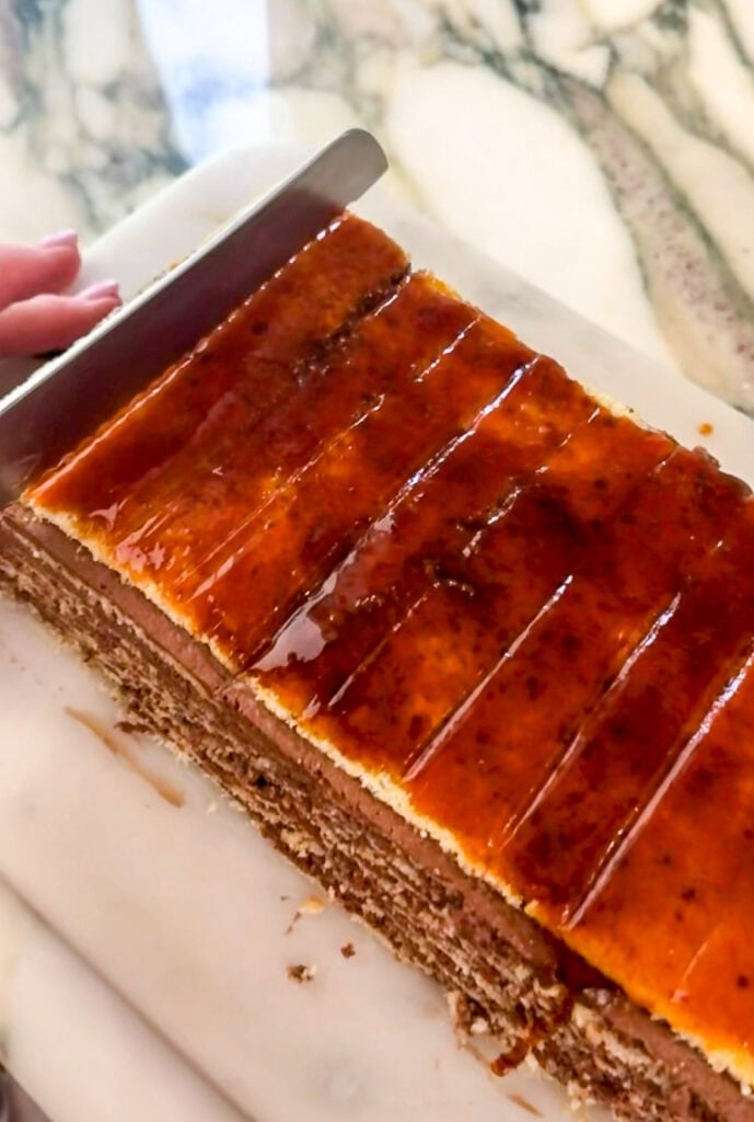 caramelized sugar spread on top of cake and scored with a knife before it cools