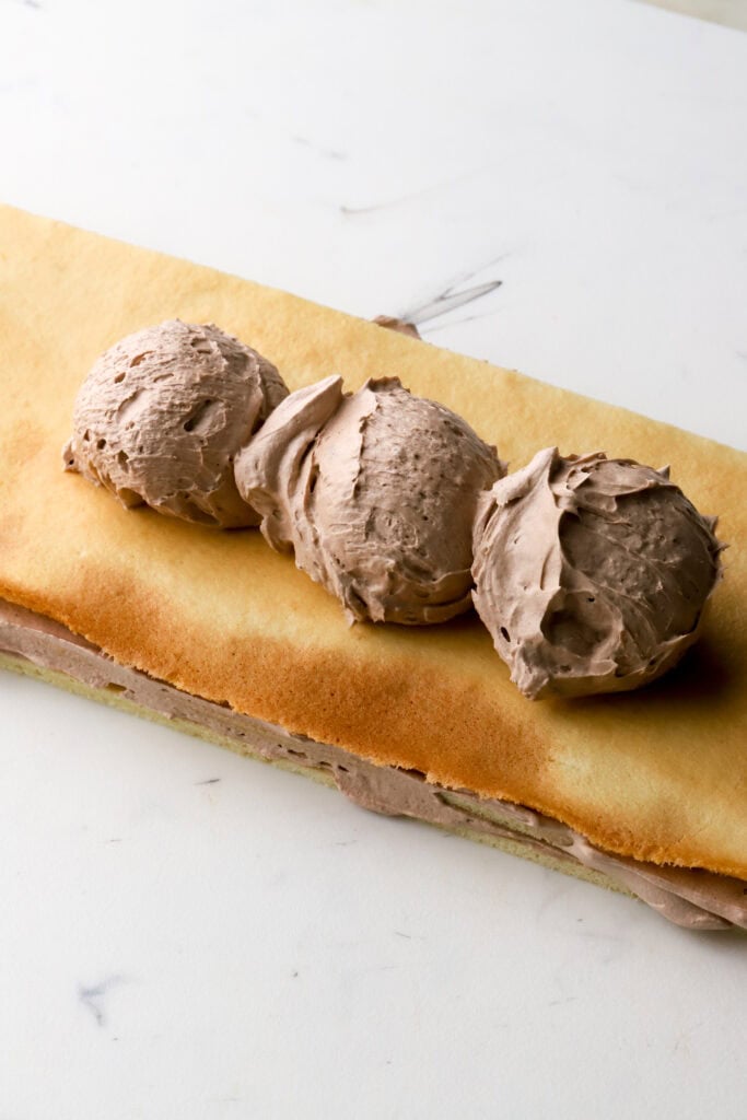 three small scoops of diplomat cream on cake layer