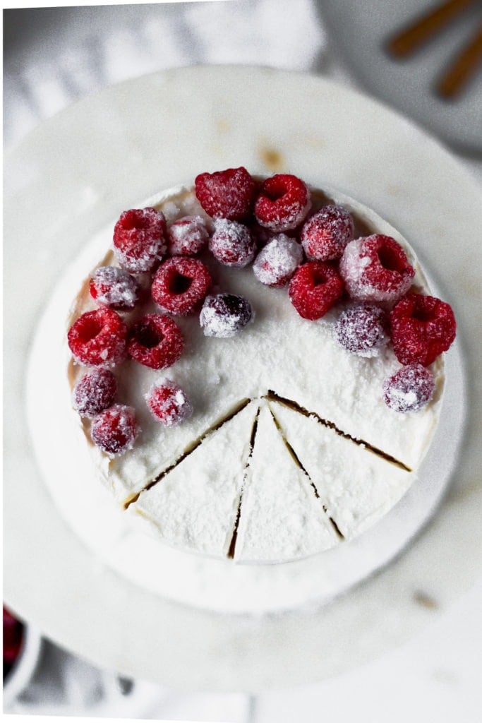 white cake with frosted raspberries on top