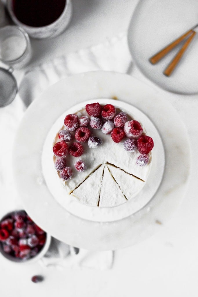 white cake with frosted raspberries on top