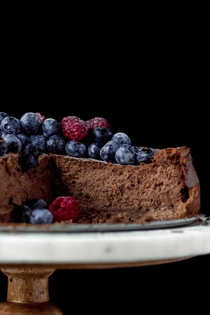 Cut into chocolate cheesecake with berries