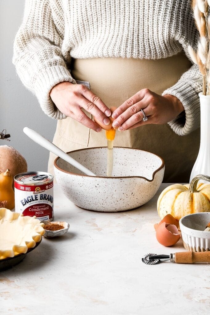 cracking the egg for the pie filling