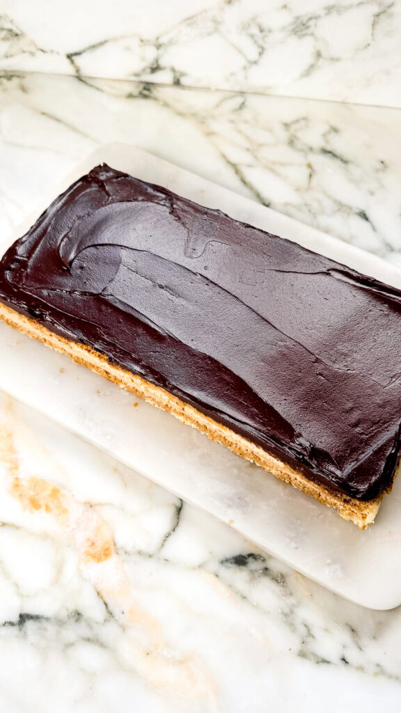 chocolate ganache spread on top of second layer of jaconde sponge
