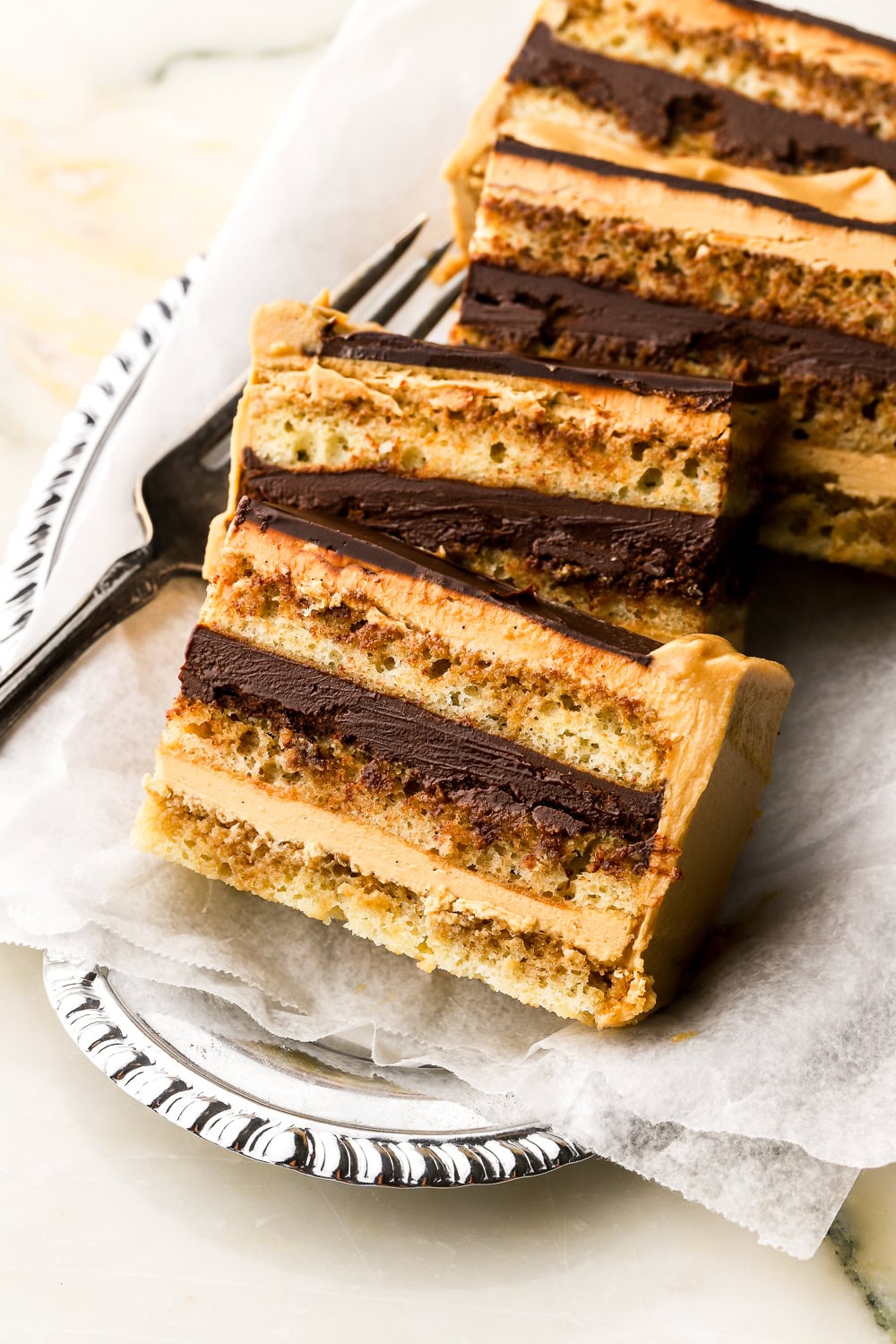 close up of a opera cakes sliced and on a silver tray with a fork