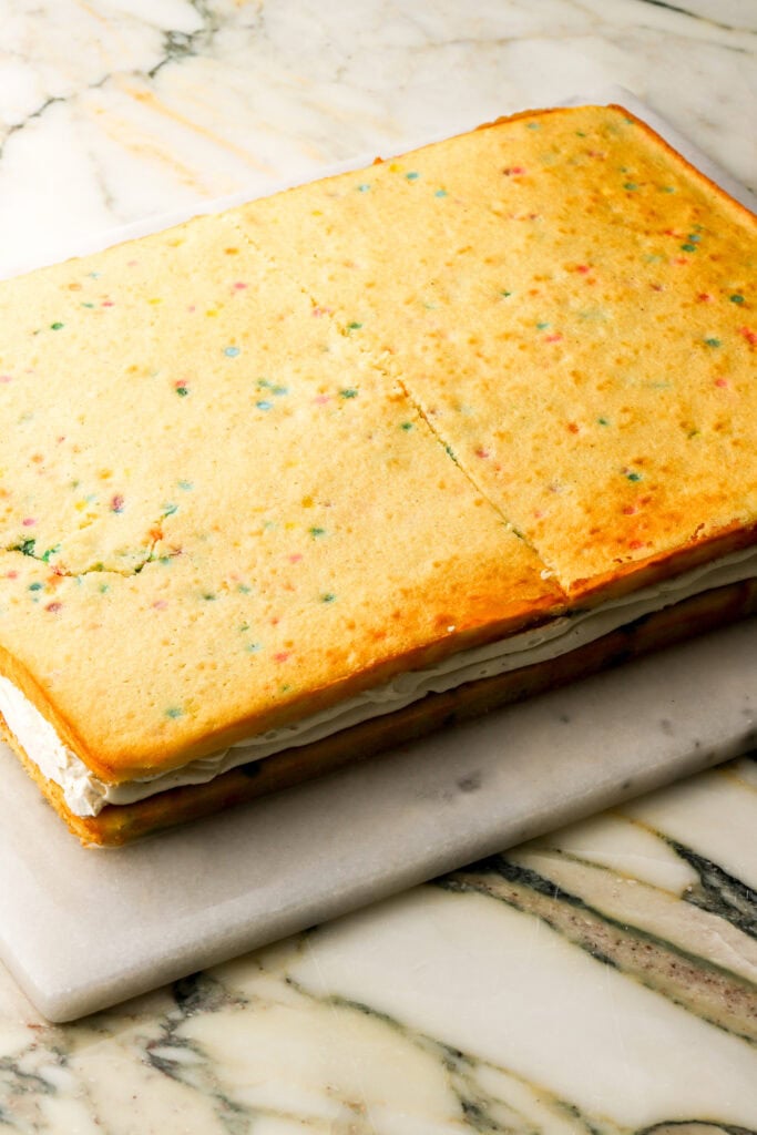 top layer of cake placed on top of the custard and frosting 