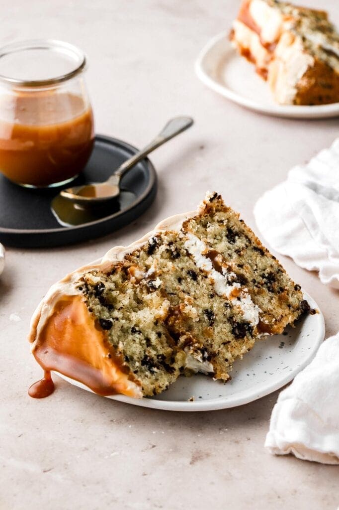 slice of chocolate chip cake with vanilla buttercream and caramel drizzle