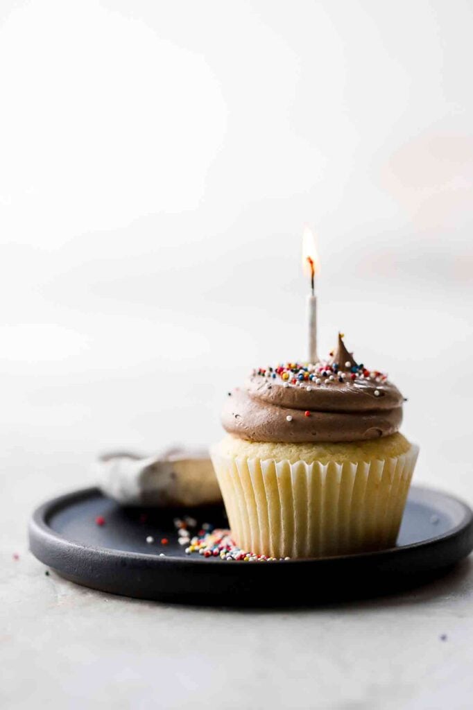 birthday cake cupcakes with lit candle and sprinkles