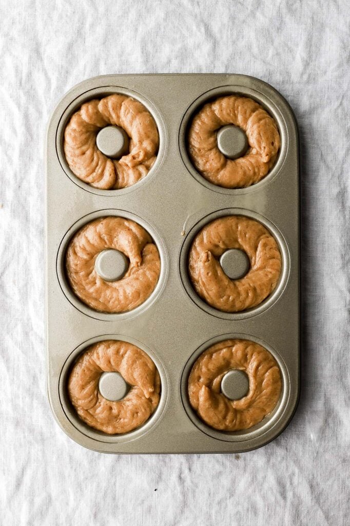 pipe donut batter into donut molds