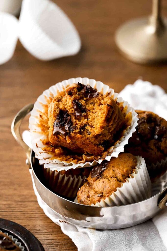 bite taken out of a pumpkin muffin with melted chocolate chunks