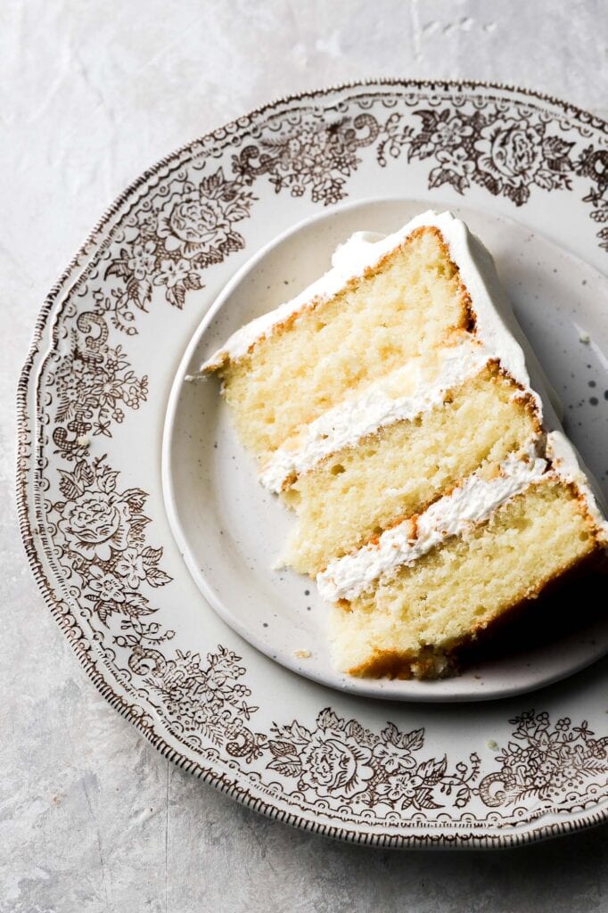 slice of 8 inch vanilla cake on a vintage plate