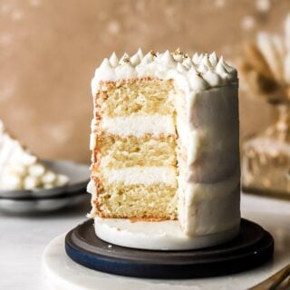 slice cut out of the cake to show three layers of vanilla cake and buttercream