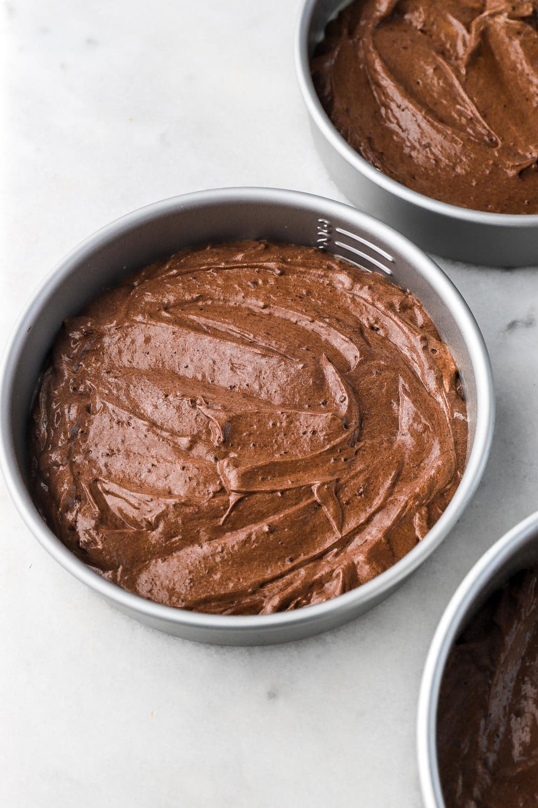 chocolate cake batter in pans