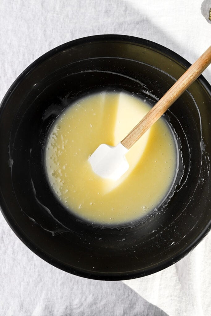 white chocolate ganache melted in a bowl with a spatula
