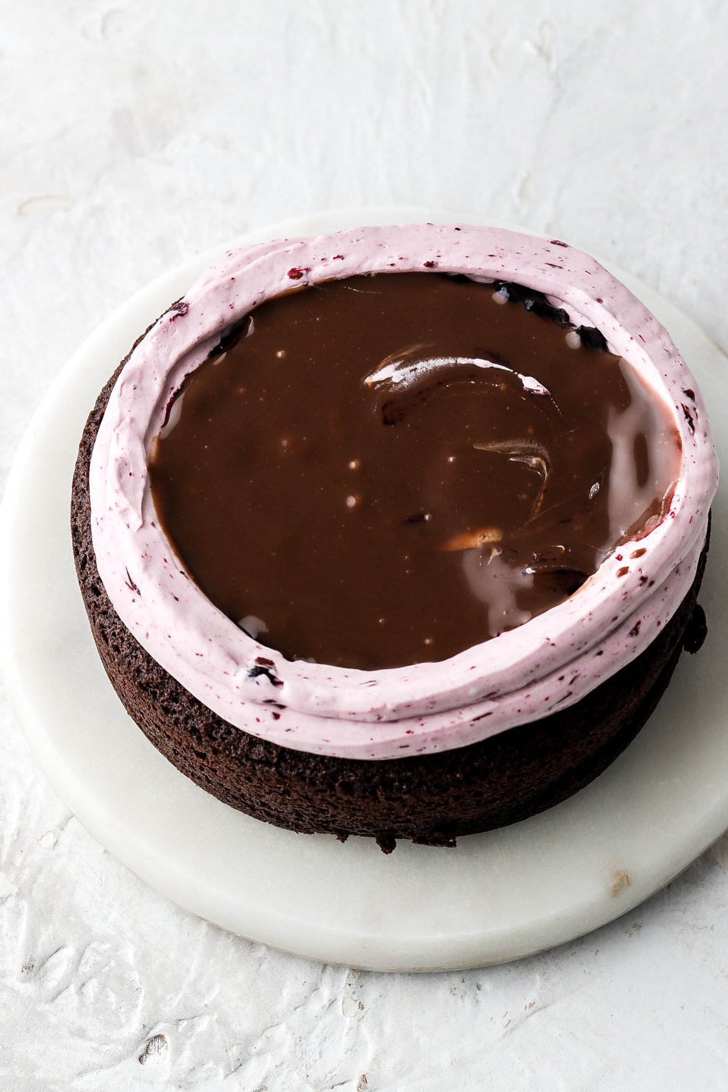 Border of blueberry buttercream, blueberry jam filling and topped with chocolate ganache