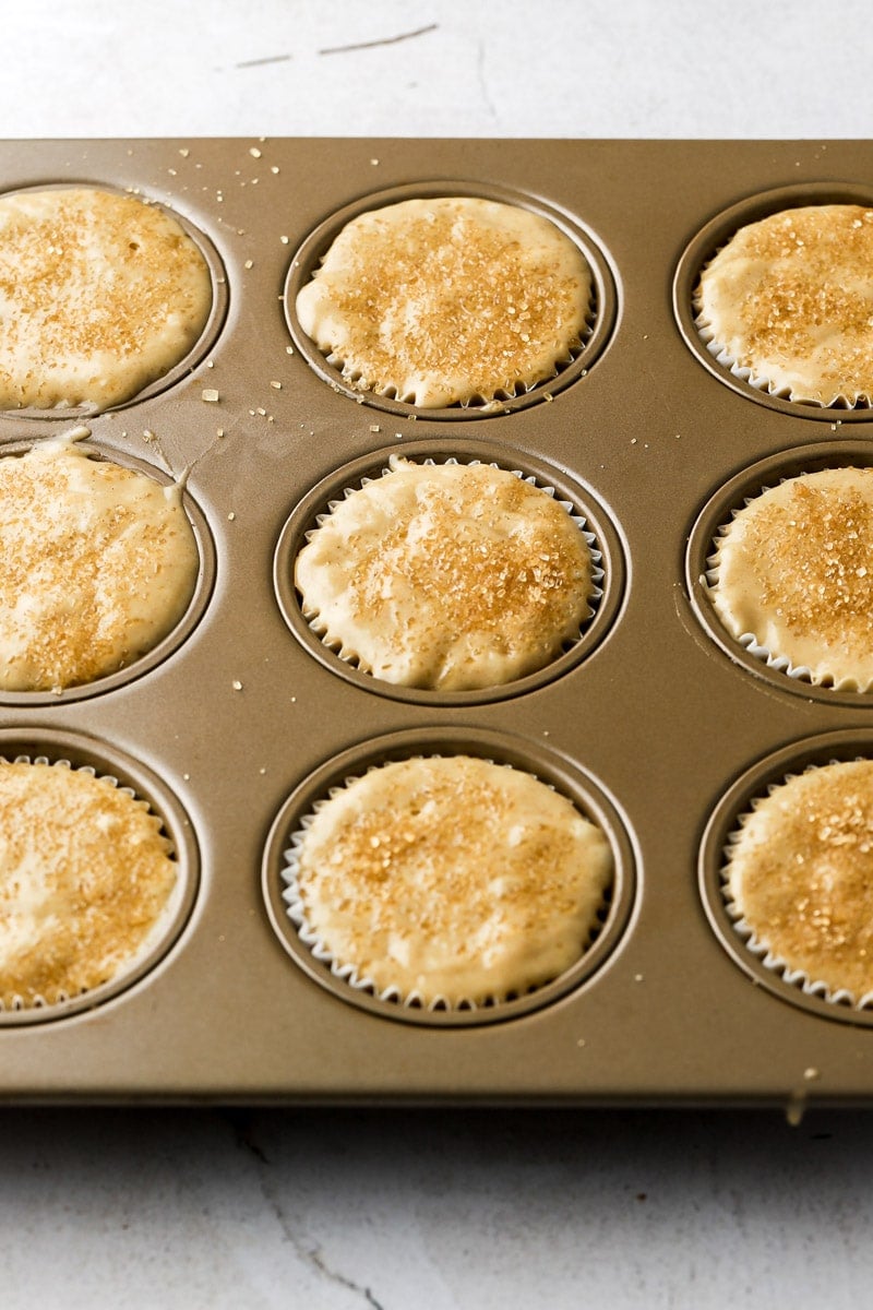 muffin batter in muffin tins with a sprinkling of raw sugar