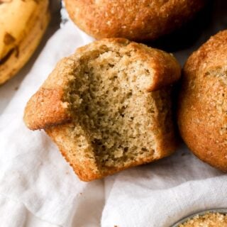 banana bread muffins on a towel with a bite taken out