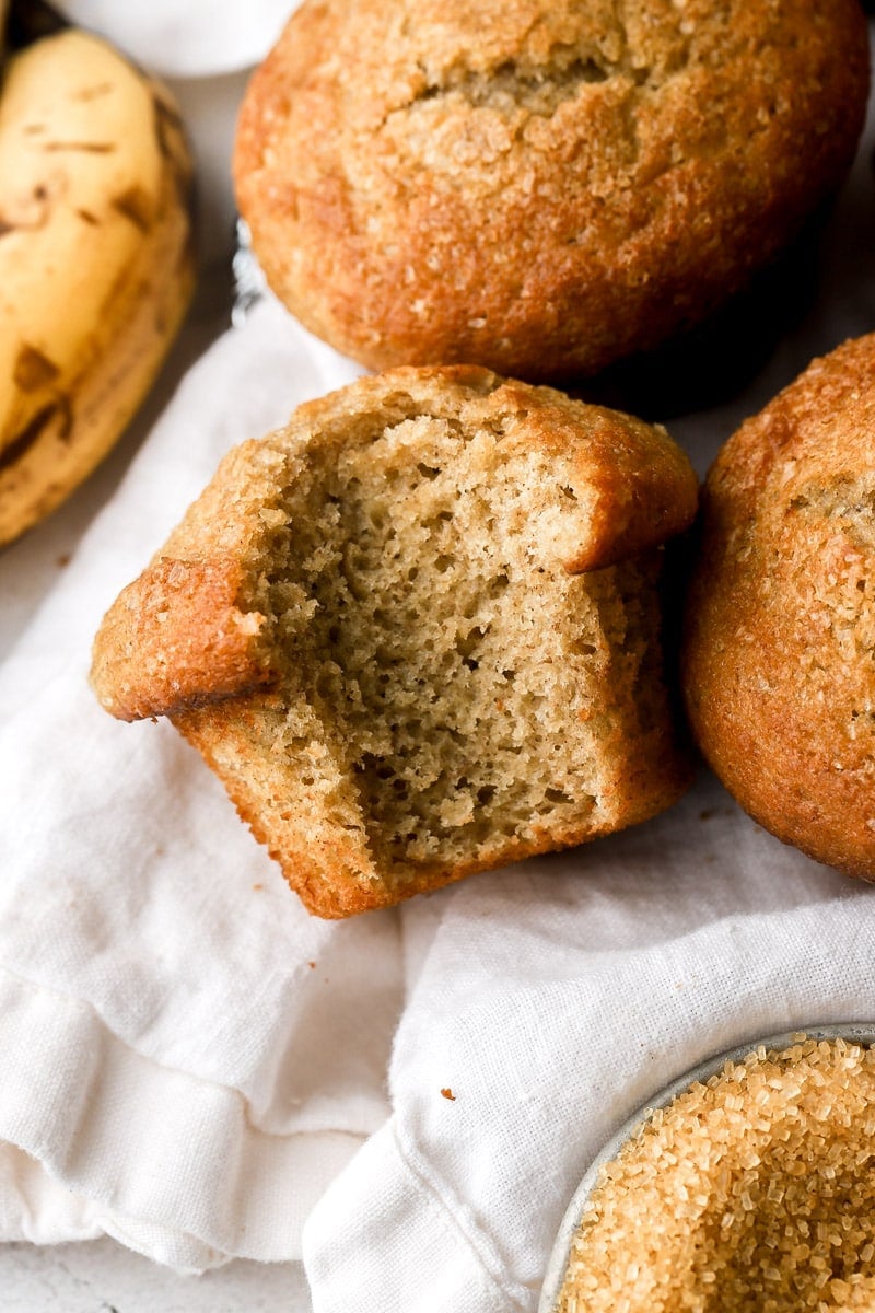 banana bread muffins on a towel with a bite taken out