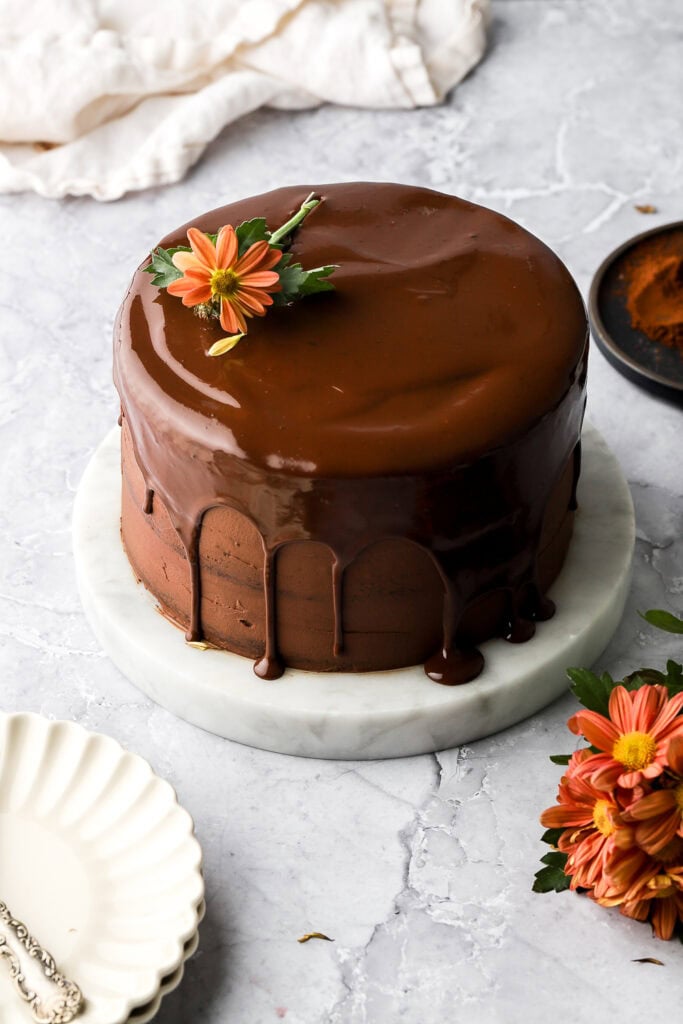 Finished chocolate ganache cake with chocolate drip and a flower on top