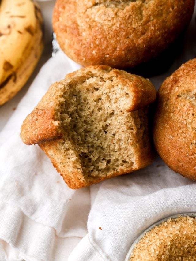 banana bread muffins on a towel with a bite taken out