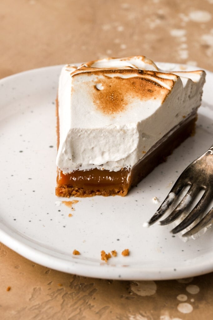 slice of caramel tart on a plate with a bite taken out