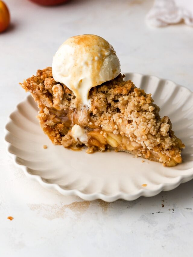 slice of dutch apple pie on a plate with ice cream on top.