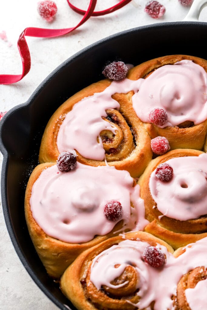 close up of cranberry orange cinnamon rolls with cranberry glaze