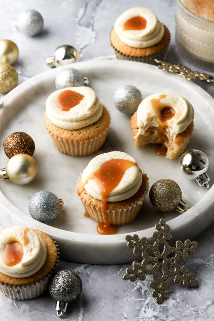 eggnog cupcakes with caramel drip on a plate with ornaments