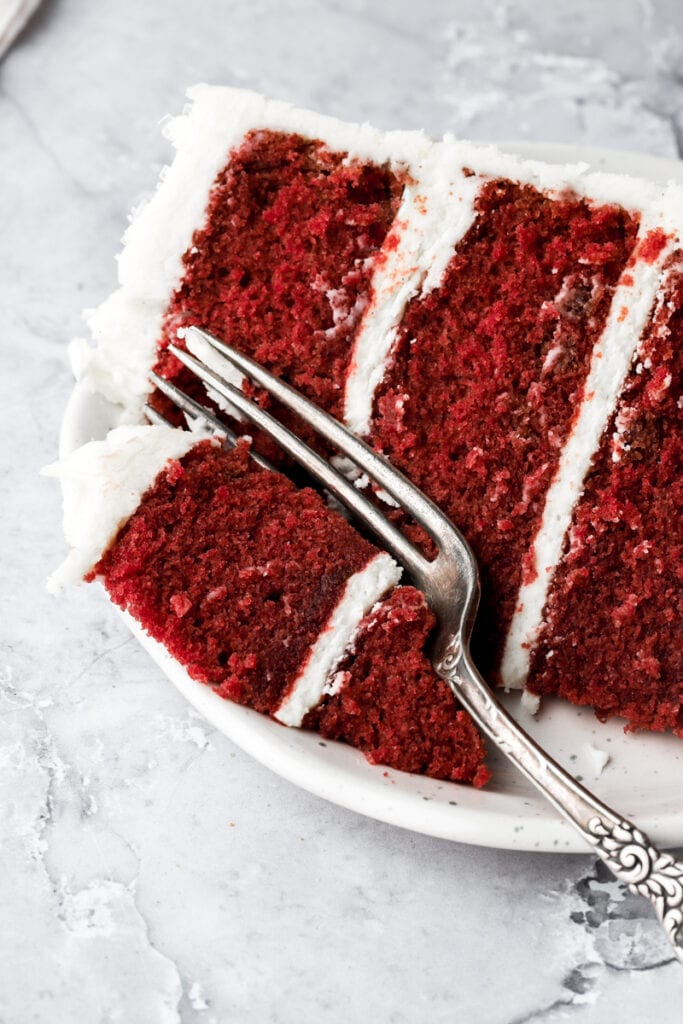 slice of red velvet cake on a plate with a fork