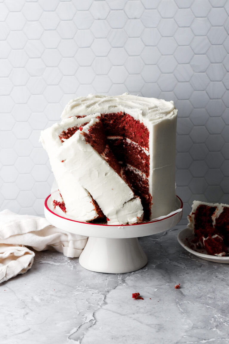 red velvet cake with slices cut on a cake stand