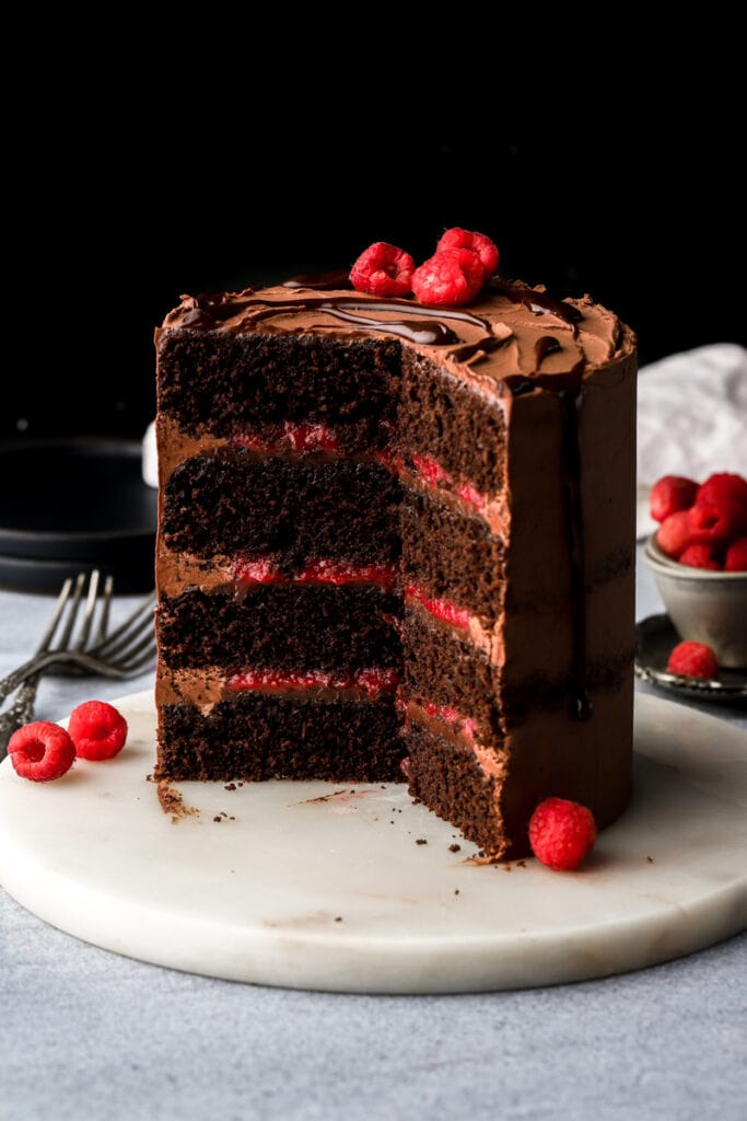 four layers of chocolate cake with chocolate ganache frosting and raspberry filling