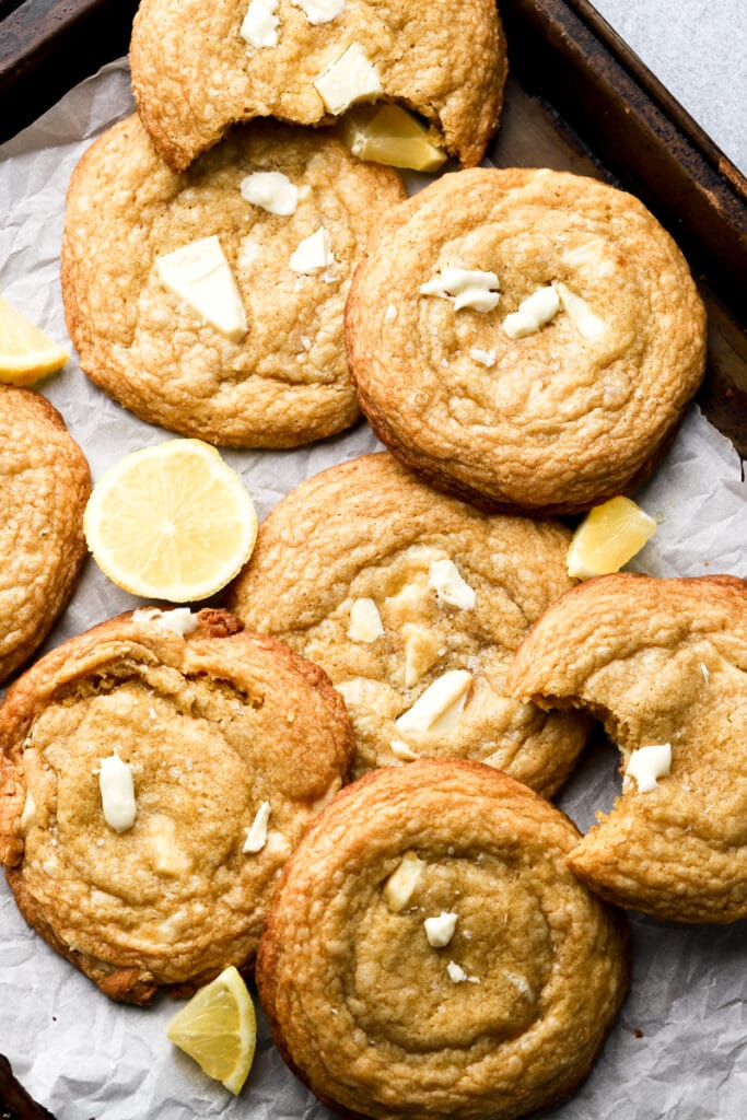 white chocolate lemon cookies on a cookie sheet with lemon slices
