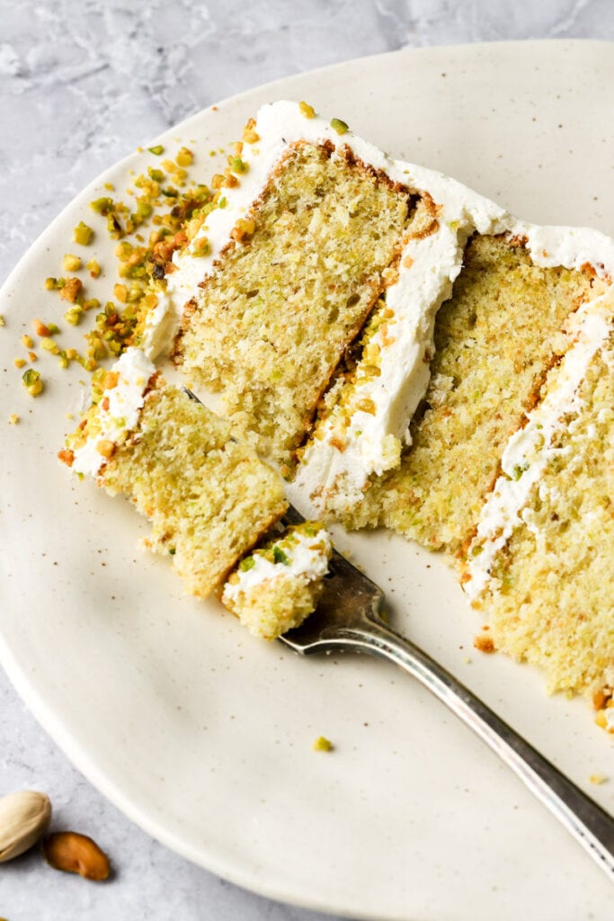 slice of pistachio cake with a bite taken out and a fork