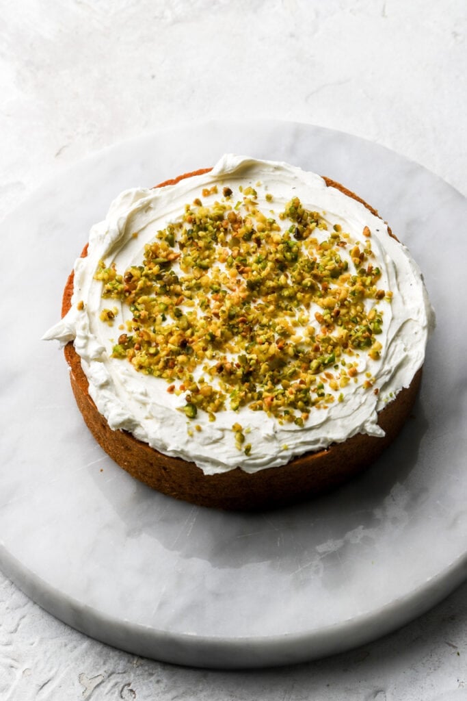 pistachio cake with white chocolate buttercream and ground pistachios
