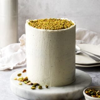 pistachio layer cake frosted with white chocolate buttercream and topped with chopped pistachios