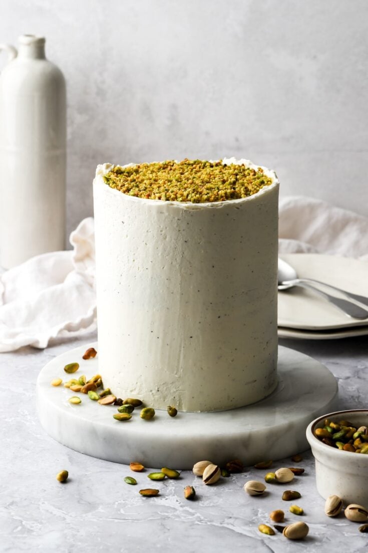 pistachio layer cake frosted with white chocolate buttercream and topped with chopped pistachios