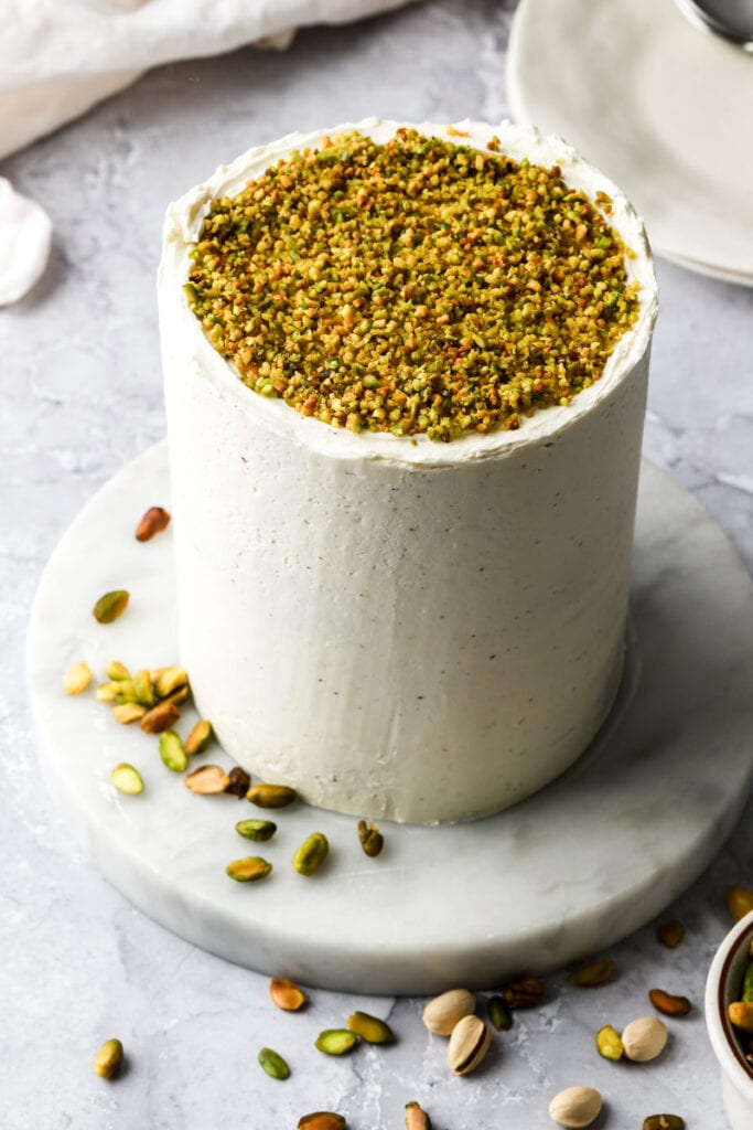 pistachio cake with white chocolate buttercream and ground pistachios on top