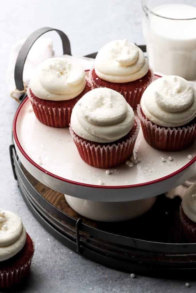 Four red velvet cupcakes frosted with cream cheese frosting