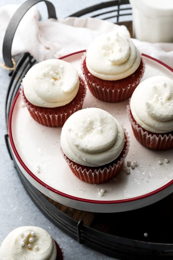 Four red velvet cupcakes frosted with cream cheese frosting