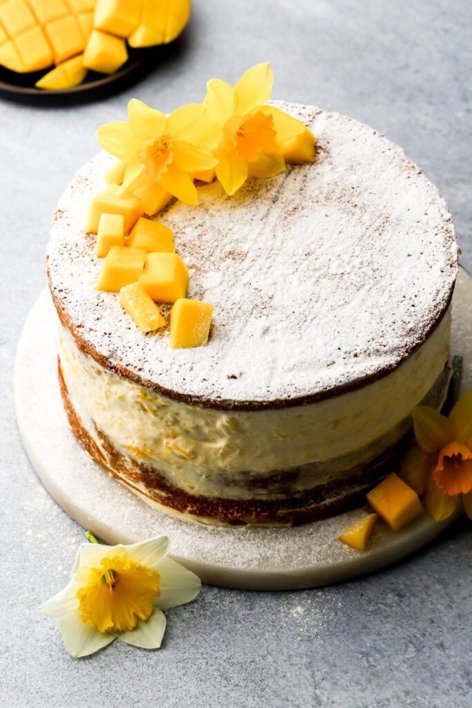 mango cake topped with powdered sugar and flowers