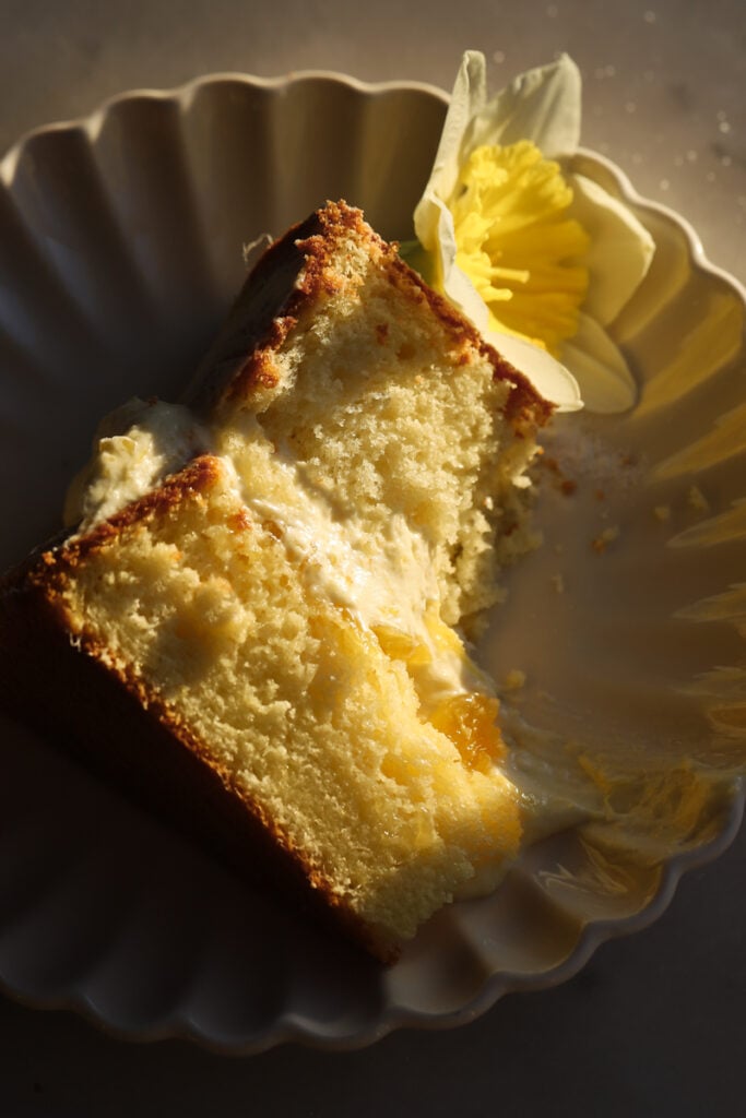 mango cake sliced on a plate and a bite taken out