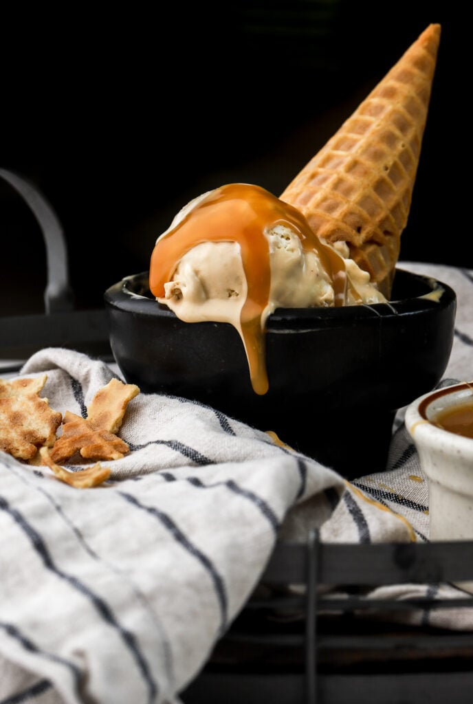caramel macchiato ice cream in a bowl with a cone and caramel sauce
