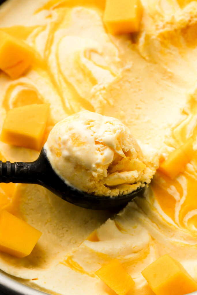 close up of mango ice cream with a scoop