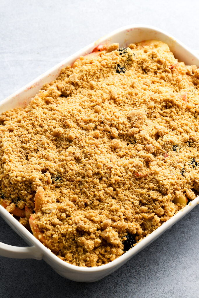 streusel placed on top of apple blackberry crumble prior to baking