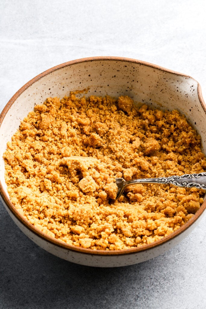 graham cracker streusel mixed with spices and butter in a bowl