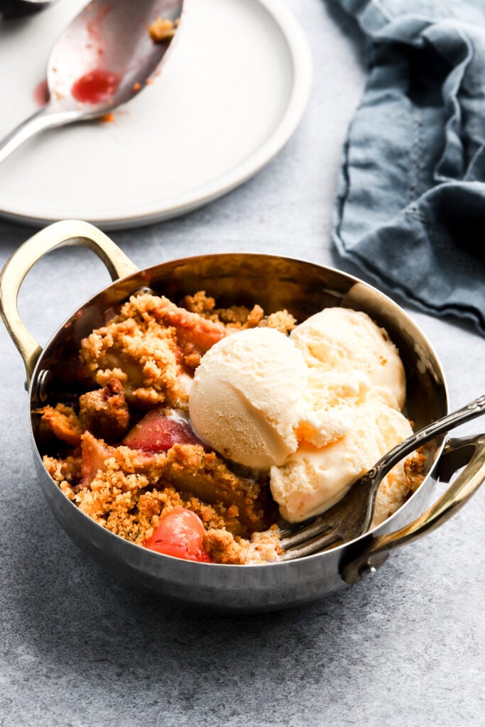 Apple Blackberry crumble with ice cream in a bowl