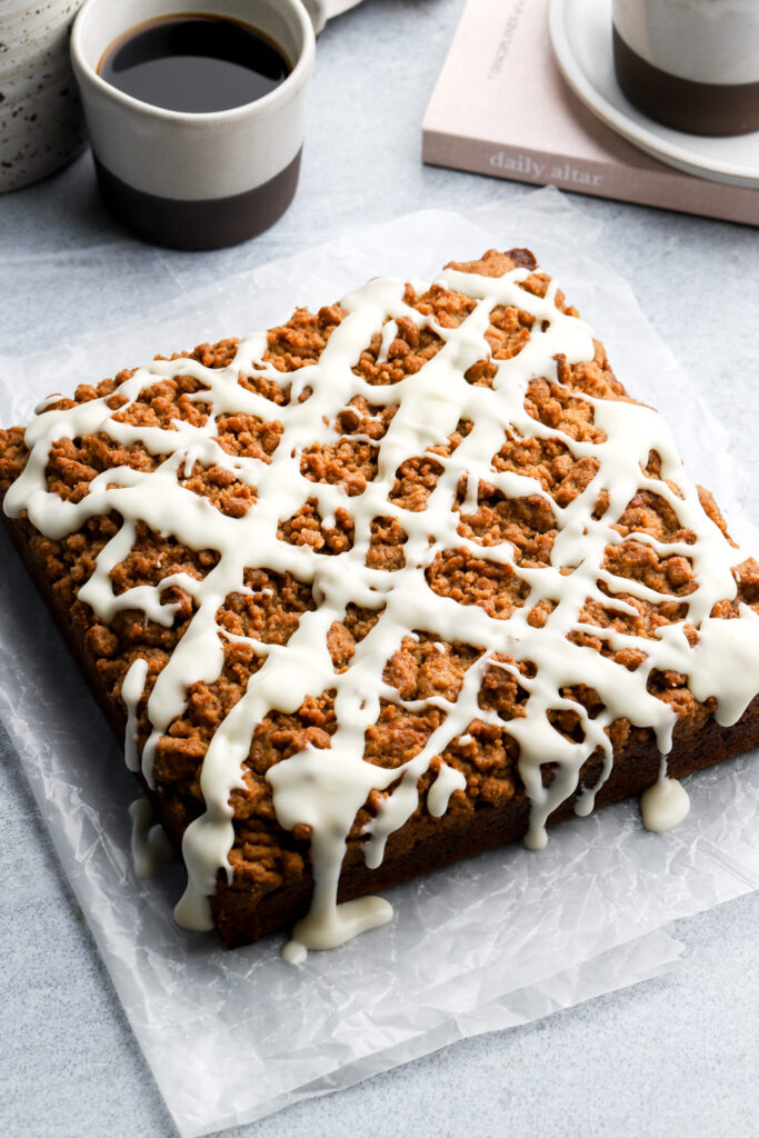 pumpkin coffee cake with streusel and cream cheese icing drizzled on top