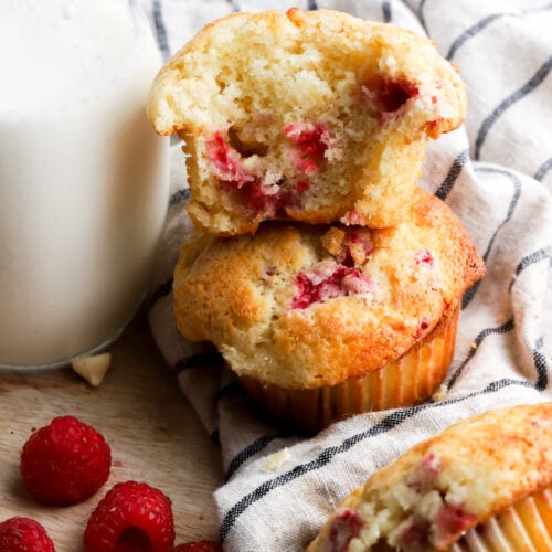 white chocolate raspberry muffins stacked with a bite taken out