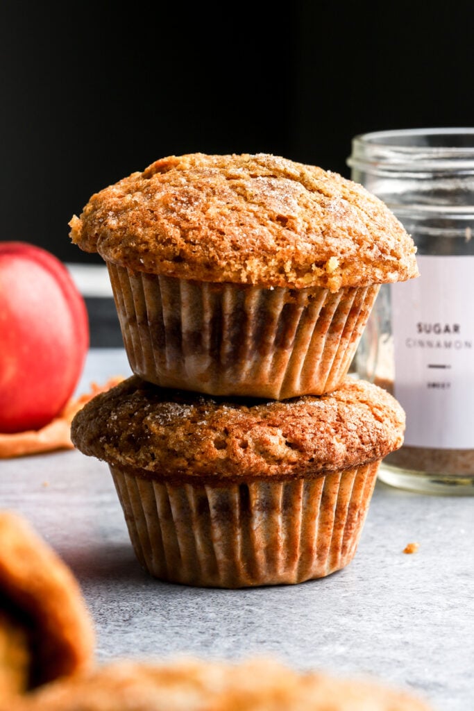 apple muffins stacked with an apple in the background