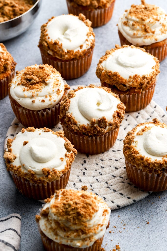 apple pie cupcakes frosted with whipped cream frosting and topped with streusel topping